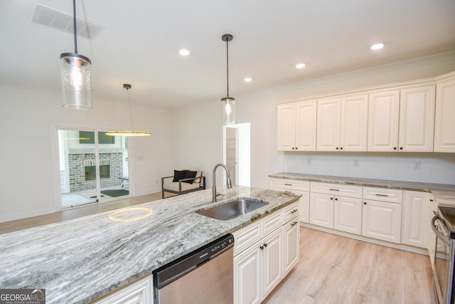 kitchen featuring sink, white cabinetry, light stone counters, appliances with stainless steel finishes, and pendant lighting