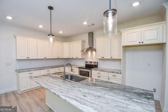 kitchen featuring sink, electric range, pendant lighting, wall chimney range hood, and white cabinets