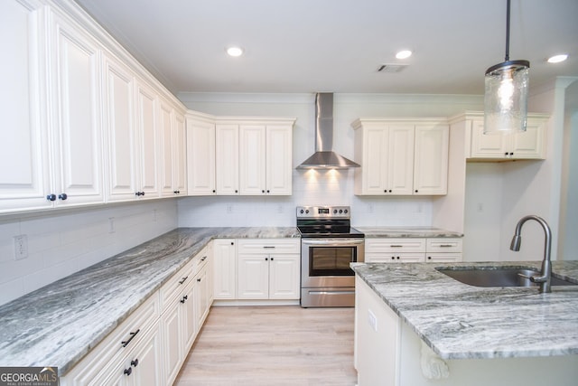 kitchen with electric stove, sink, hanging light fixtures, light stone counters, and wall chimney exhaust hood