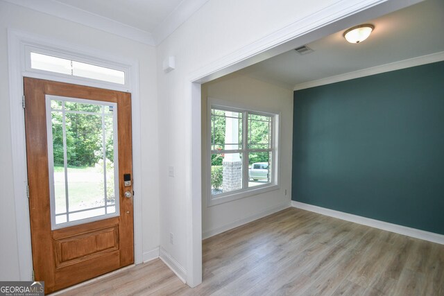 entrance foyer featuring light hardwood / wood-style floors, a wealth of natural light, and crown molding