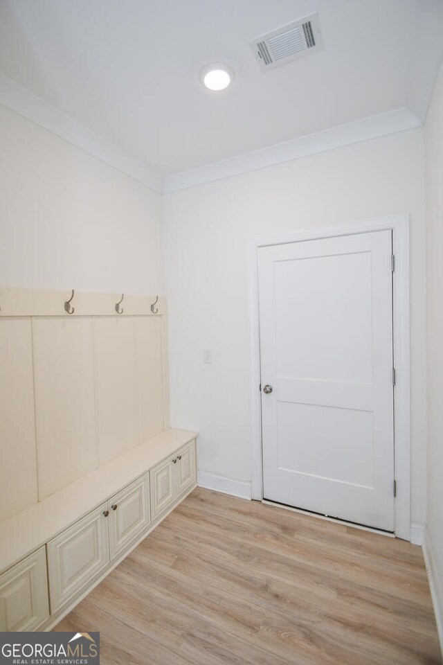 mudroom featuring light hardwood / wood-style flooring and crown molding