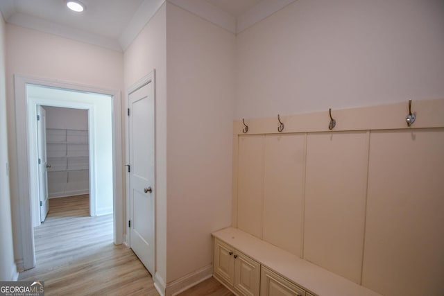 mudroom with ornamental molding and light hardwood / wood-style flooring