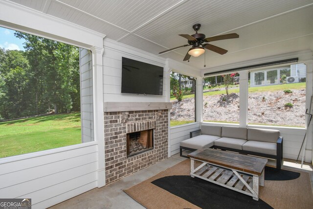 sunroom featuring an outdoor brick fireplace and ceiling fan