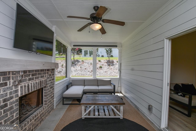 sunroom with a brick fireplace and ceiling fan
