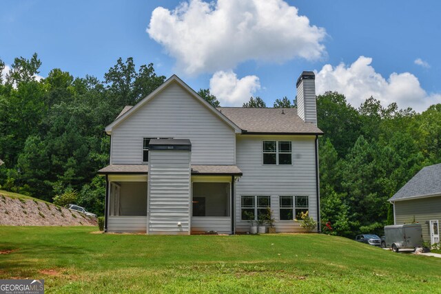 rear view of house featuring a yard