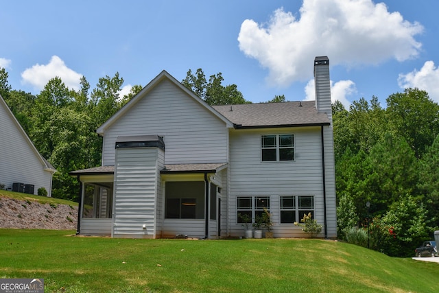 rear view of property with a yard and a sunroom