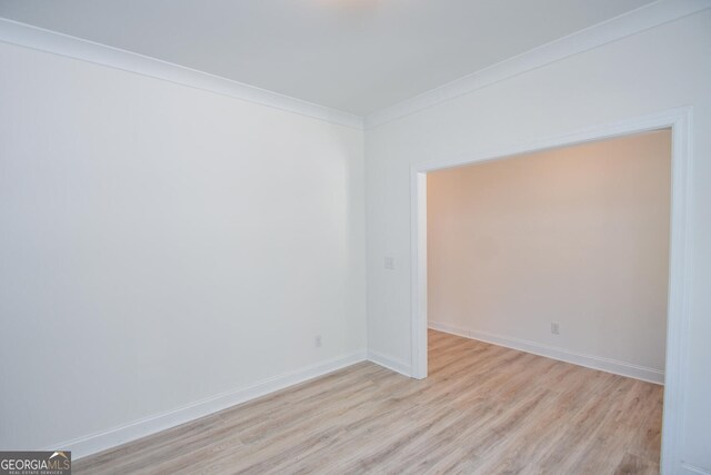 empty room featuring light hardwood / wood-style floors and ornamental molding