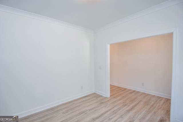 unfurnished room featuring ornamental molding and light hardwood / wood-style flooring
