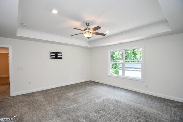 unfurnished room featuring ceiling fan, ornamental molding, a tray ceiling, and carpet floors