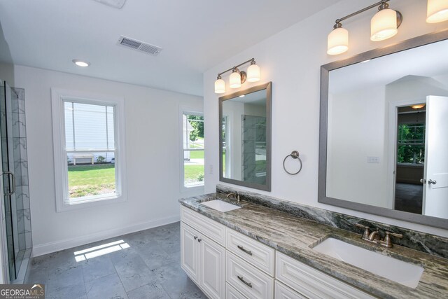 bathroom featuring an enclosed shower, tile patterned floors, and dual bowl vanity