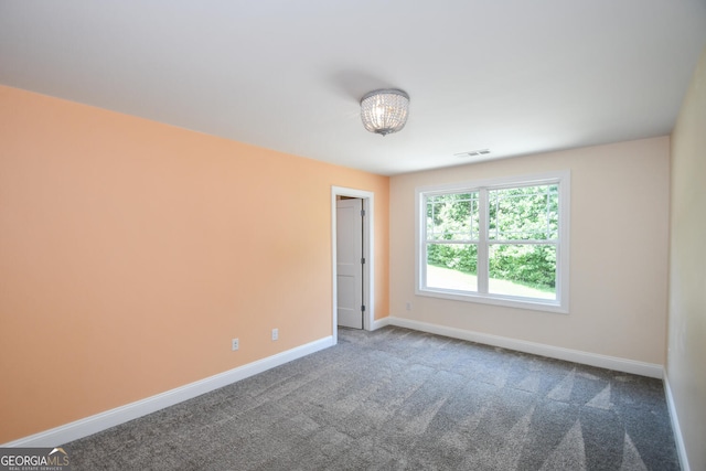 empty room featuring dark colored carpet