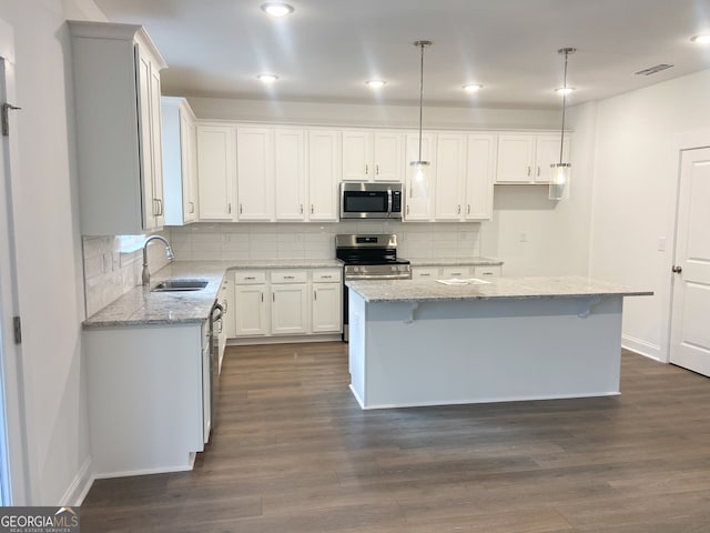 kitchen with white cabinets, a center island, stainless steel appliances, and sink