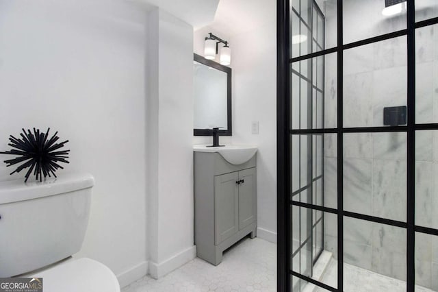 bathroom with vanity, toilet, and a tile shower