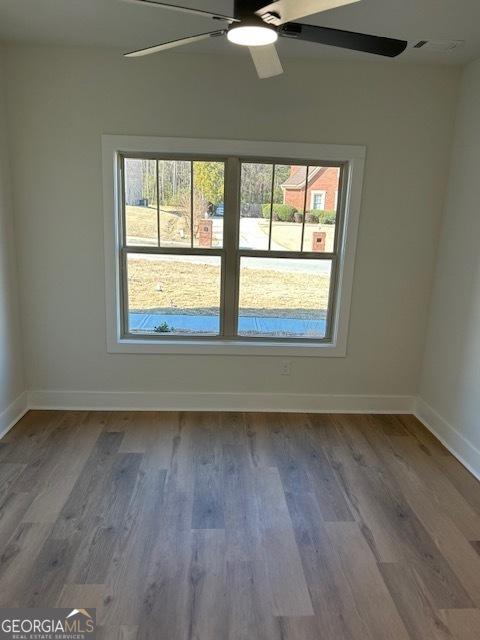 spare room featuring hardwood / wood-style floors and ceiling fan