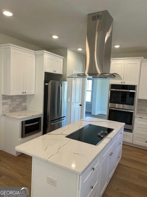 kitchen featuring white cabinets, a kitchen island, island exhaust hood, and stainless steel appliances