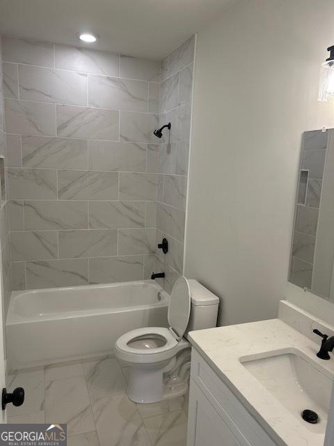 full bathroom featuring vanity, toilet, and tiled shower / bath