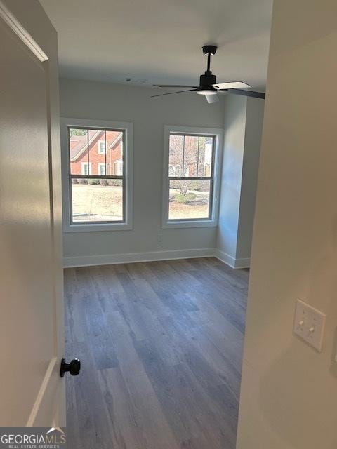 unfurnished room featuring dark hardwood / wood-style floors and ceiling fan