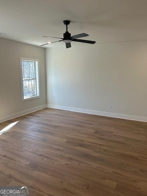 empty room with ceiling fan and dark hardwood / wood-style floors