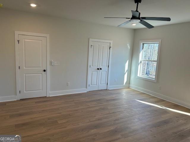 empty room with hardwood / wood-style flooring and ceiling fan