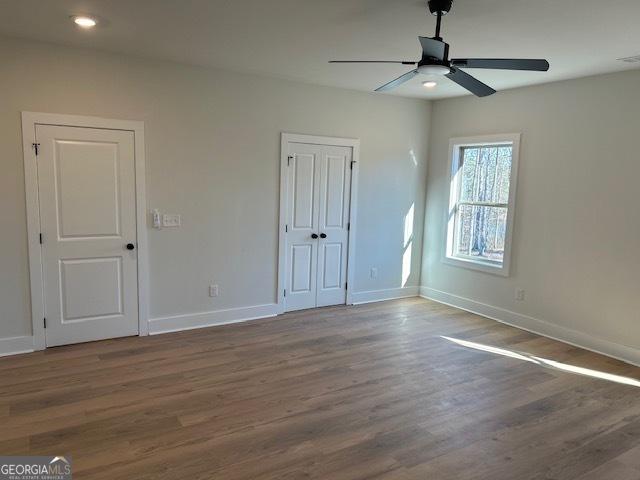 unfurnished bedroom featuring hardwood / wood-style flooring and ceiling fan