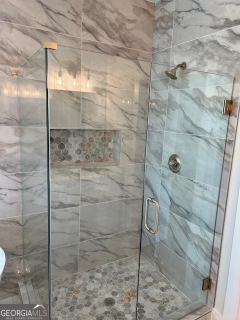 bathroom featuring a shower with shower door