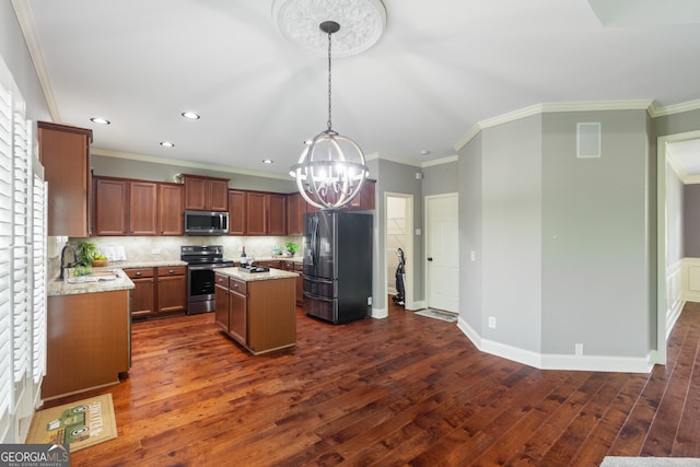 kitchen featuring appliances with stainless steel finishes, dark wood-type flooring, pendant lighting, a center island, and tasteful backsplash