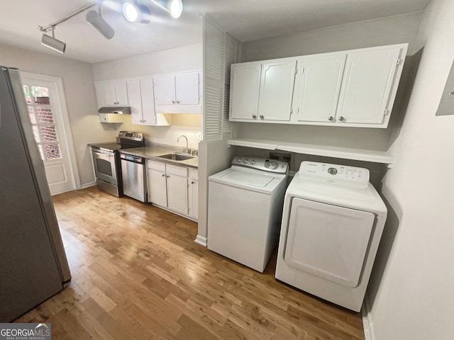 laundry room with track lighting, sink, light hardwood / wood-style flooring, and independent washer and dryer