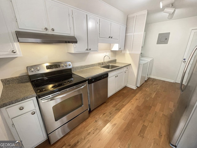 kitchen with sink, white cabinetry, washer and dryer, stainless steel appliances, and light hardwood / wood-style floors