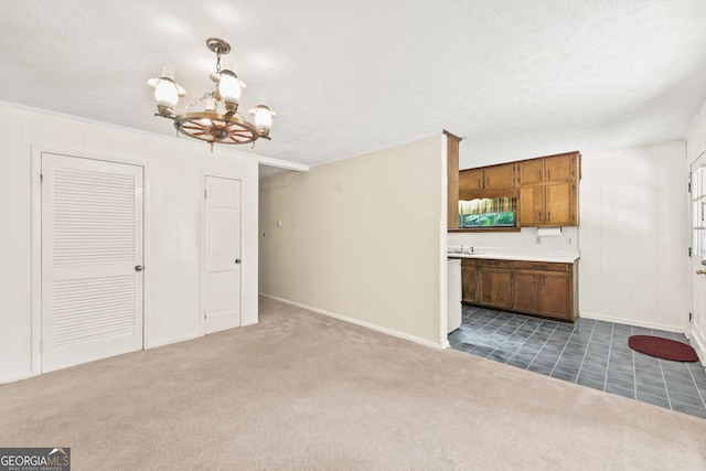 unfurnished living room featuring a notable chandelier and carpet flooring