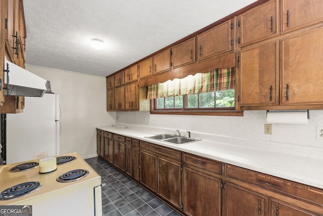 kitchen featuring white appliances, sink, dark tile patterned flooring, a textured ceiling, and custom exhaust hood