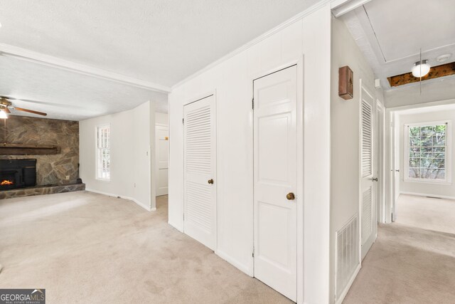 hallway featuring light carpet and a textured ceiling