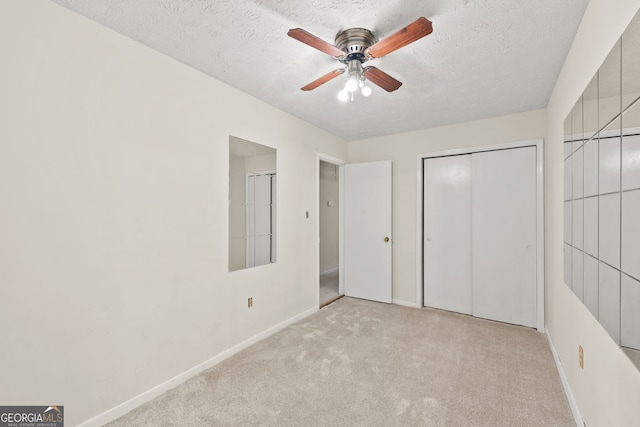 unfurnished bedroom with light carpet, a textured ceiling, and ceiling fan