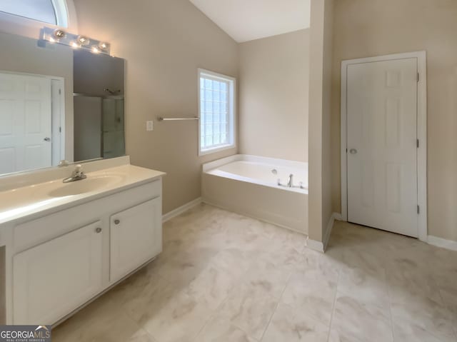 bathroom with vanity, shower with separate bathtub, and vaulted ceiling