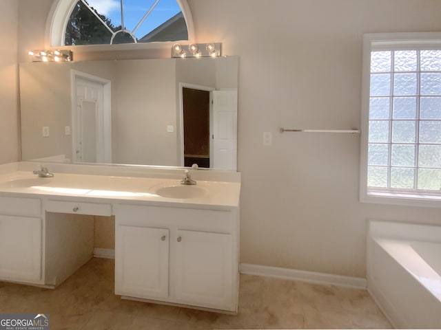 bathroom with vanity, tile patterned flooring, and a washtub