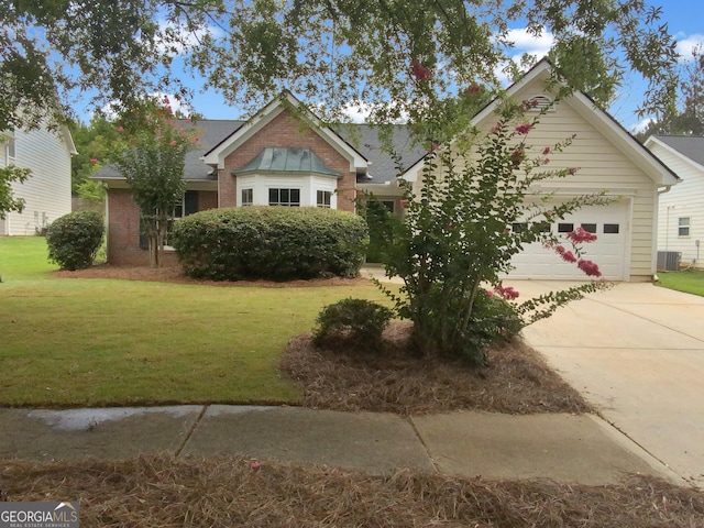 view of front of property with a garage, a front lawn, and central air condition unit