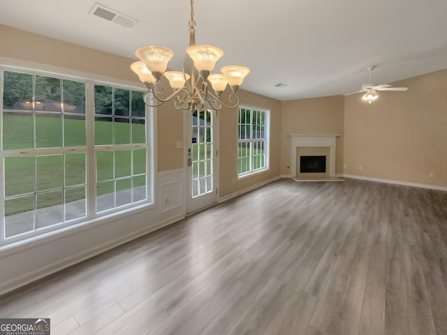 unfurnished living room with hardwood / wood-style flooring and ceiling fan with notable chandelier