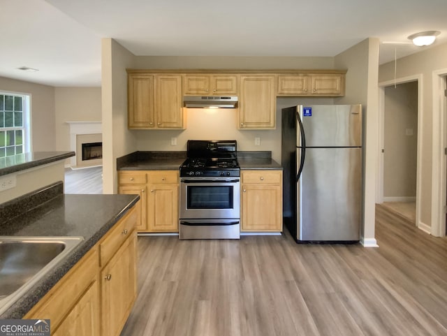 kitchen featuring stainless steel appliances, sink, light brown cabinetry, and light hardwood / wood-style flooring