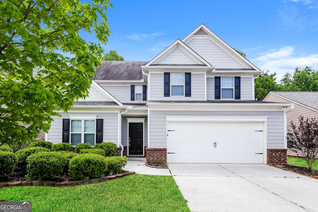 view of front of property with driveway, a garage, and brick siding