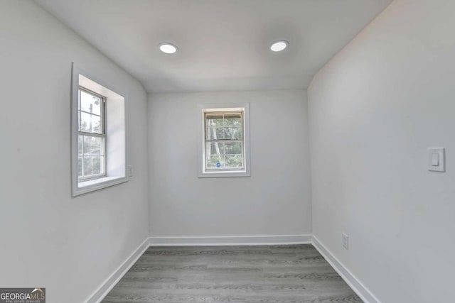 spare room with wood-type flooring and a healthy amount of sunlight