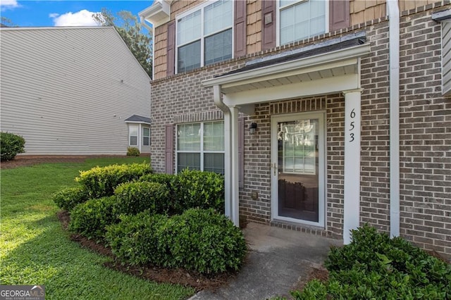 property entrance with a lawn