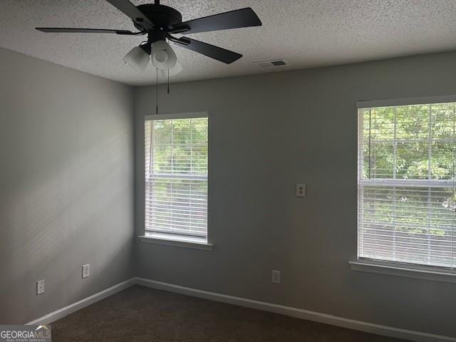 unfurnished room with ceiling fan, carpet flooring, a textured ceiling, and plenty of natural light