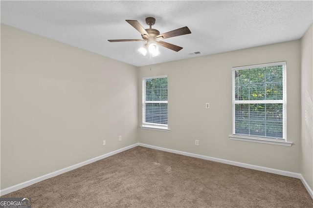 carpeted empty room featuring a textured ceiling and ceiling fan