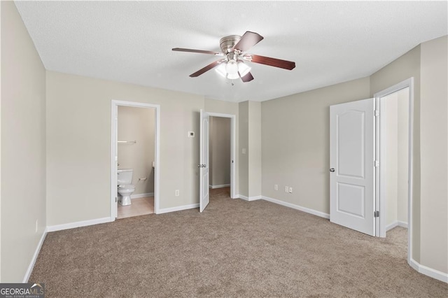 unfurnished bedroom with light colored carpet, ensuite bath, and ceiling fan