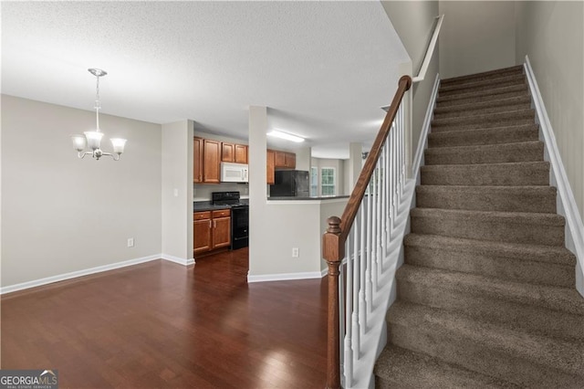 stairs with a notable chandelier and dark hardwood / wood-style floors