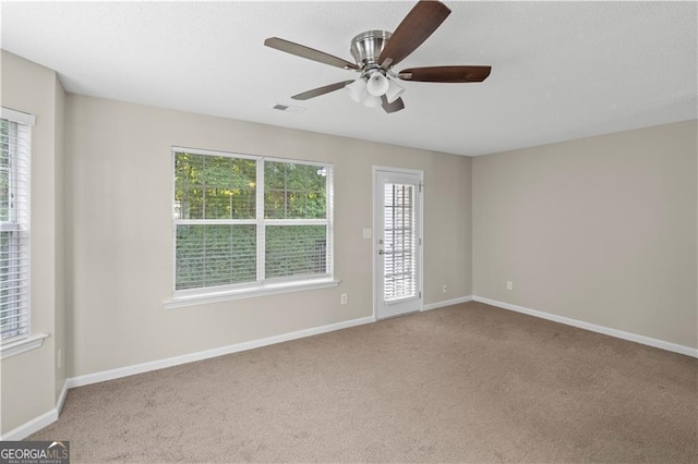 unfurnished room with carpet floors, ceiling fan, and a healthy amount of sunlight