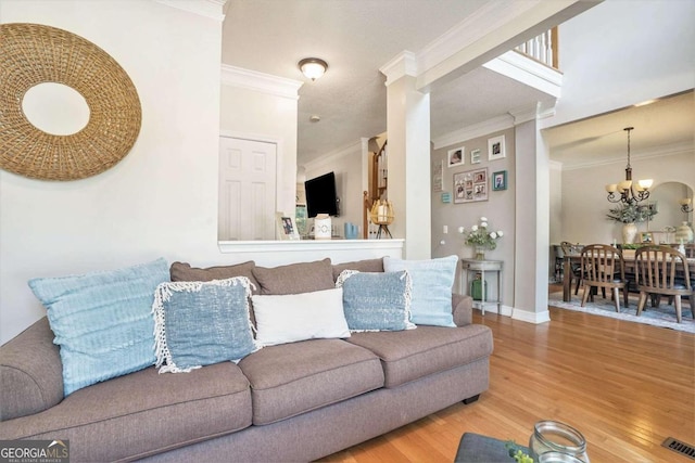 living room featuring crown molding, wood-type flooring, and a chandelier