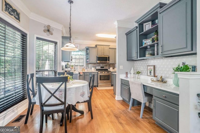 dining area featuring light wood-type flooring and ornamental molding