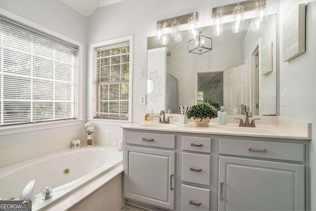 bathroom featuring vanity and tiled bath