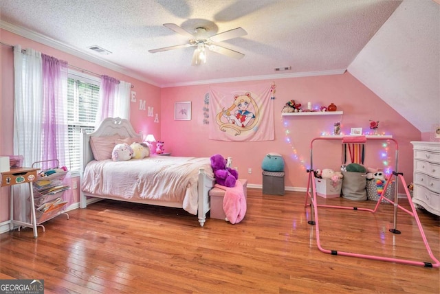 bedroom with hardwood / wood-style floors, ceiling fan, ornamental molding, and a textured ceiling