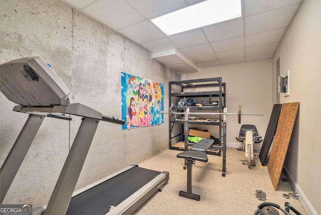 workout room featuring a paneled ceiling and carpet floors